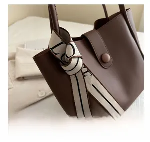 Détail de l'anse d'un sac cabas en PU marron foncé avec ruban en toile imprimé LOVE beige