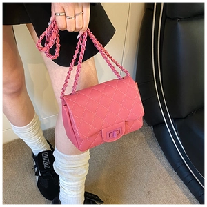 Detailed view of pink quilted leather bag featuring a gold turn-lock and chain strap