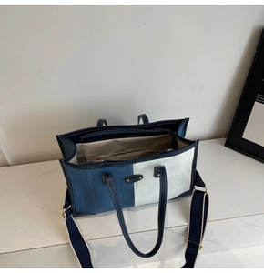 Dettaglio della borsa tote in tela blu e bianca con interno spazioso e tasca con zip