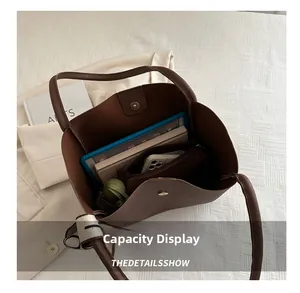 Vue de dessus montrant la grande capacité du cabas marron avec tablette et parapluie
