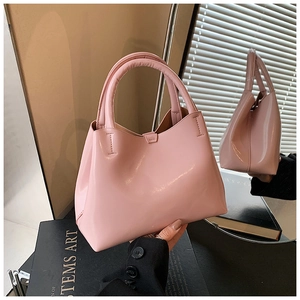 Detail of pink patent leather handbag with glossy finish and cylindrical top handles
