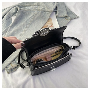 Detail view of mini crossbody bag storage showing phone and lipstick with scarf handle