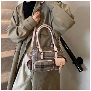 Détail du sac à bandoulière en laine à carreaux avec garniture en cuir rose et poches