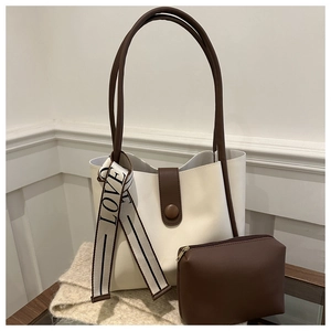 Détail du grand sac cabas minimaliste crème avec anses marron sur un bureau en bois
