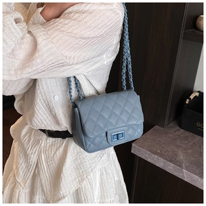 Detail of blue quilted leather bag with matching chain strap and metal turn-lock