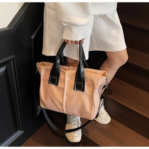 Pink and orange canvas tote bag with black PU leather straps on wooden stairs