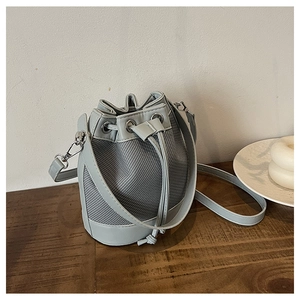 Gros plan du sac seau patchwork bleu clair avec cordon de serrage et détails argentés