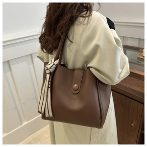 Détail du sac cabas en cuir marron avec foulard géométrique et clous dorés