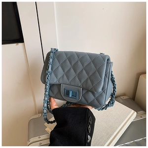 Detail of blue quilted leather bag with turn-lock clasp and chain shoulder strap