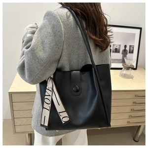 Détail du sac cabas noir en simili cuir avec ruban LOVE et fermeture à bouton métal