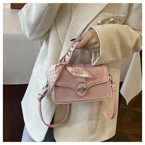 Detail of pink woven handbag with silk scarf handle and golden twist lock closure