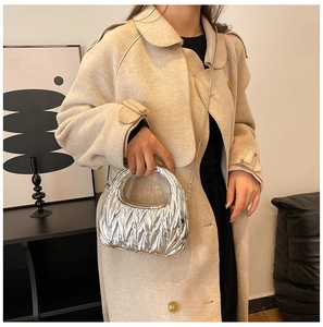 Detail of silver pleated metallic handbag with matelassé texture and chain strap