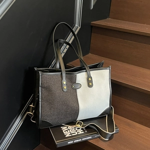 Borsa tote moderna color-block con tracolla geometrica su scala in legno scuro