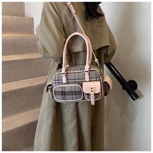 Sac bowling à carreaux de style anglais avec finitions en cuir rose porté en bandoulière