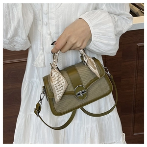 Detail of retro small square bag with silk scarf handle and metal turn-lock closure