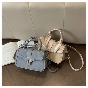 Close-up of woven texture stitching and metal circular buckle on stylish handbags