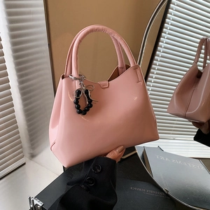 Pink patent leather handbag with silver bow charm and elegant round handle for women