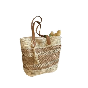 Handcrafted striped straw tote bag with brown leather handles and decorative tassel pendant