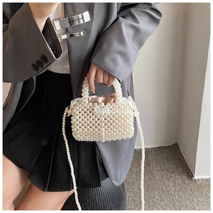 Détail du sac en perles tissées avec doublure en satin rose et ruban décoratif à nœud