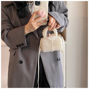 Détail d'un sac à main en perles montrant les perles ivoires et la doublure satin