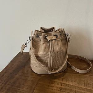 Sac seau beige minimaliste avec texture tissée kaki et bandoulière réglable