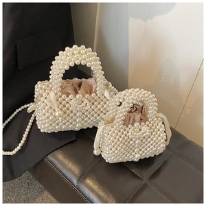 Détail du sac à main en perles blanches tressées avec doublure en satin champagne