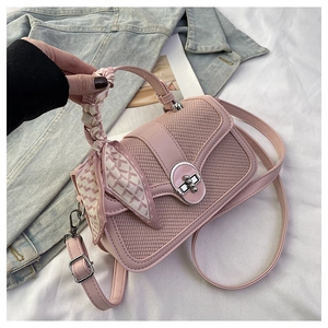 Chic pink patchwork handbag with silk scarf handle and silver twist lock on white cloth