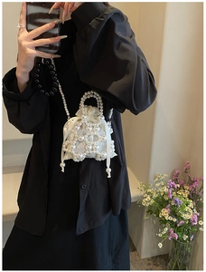 Détail du sac à main en perles blanches avec pochette en satin et bandoulière élégante