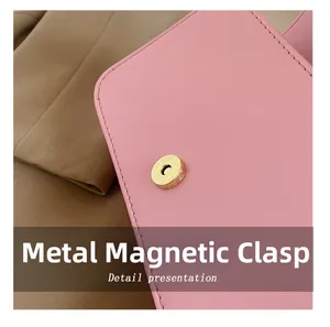 Macro detail of golden magnetic snap on pink lychee grain leather crossbody bag