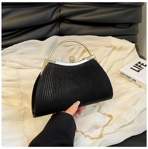 Detail of elegant black pleated evening bag with pearl rhinestone clasp and gold handle