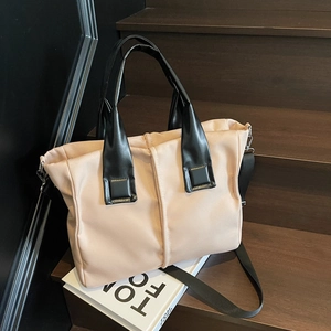 Minimalist bicolor tote bag with leather handles on a wooden staircase setting