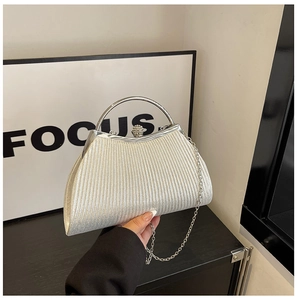 Close-up of silver pleated evening clutch bag with rhinestone clasp and metal handle