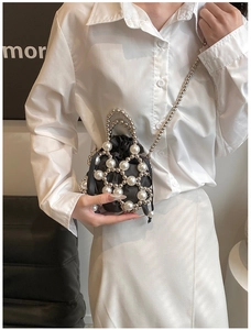 Détail du sac ajouré en perles avec pochette noire à cordon et chaîne métallique argentée