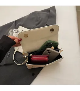 Detailed interior of a white flap bag showing large space for phones and wallet
