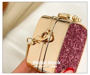 Detailed close-up of golden metal hooks and pink sequin panel on a mini evening bag