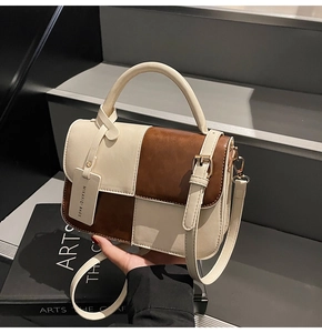 Close-up of retro color-block handbag with beige and brown PU leather and gold hardware