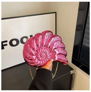 Detail of hot pink metallic nautilus shell clutch bag with gold chain strap