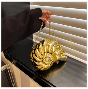 Detailed close-up of golden conch shell evening bag with metallic mirror finish and chain