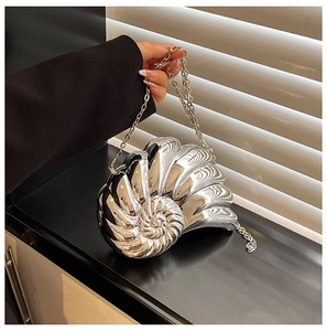 Close-up of silver shell clutch bag featuring metallic spiral texture and chain strap