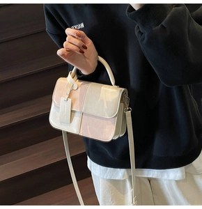 Detail shot of tricolor contrast leather crossbody bag in beige and pink on a model