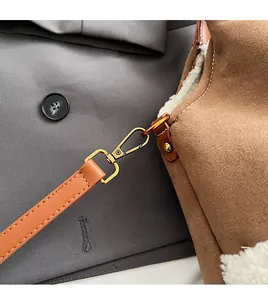 Détail du crochet doré et bandoulière en cuir sur sac fourre-tout en daim marron