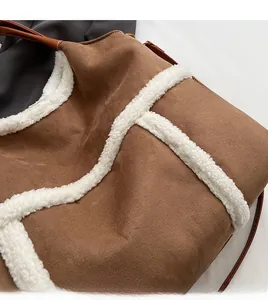 Détail du sac cabas en daim marron avec bordure en peau de mouton blanche et lanière