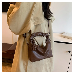 Detail der dunkelbraunen Dumpling-Tasche mit Cloud-Griff und geknotetem Quasten-Dekor
