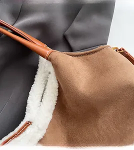 Détail du sac en daim marron avec doublure en peau de mouton et bandoulière en cuir cousu