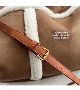 Détail de la bandoulière en cuir réglable avec boucles dorées sur sac cabas en daim