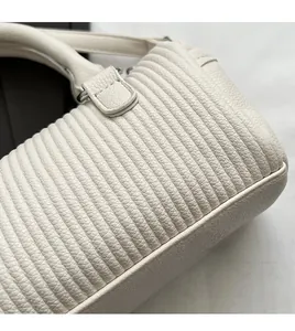 Detail of ivory pleated leather handbag showing vertical quilting and lychee texture