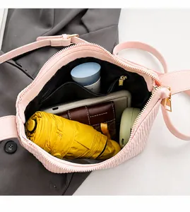 Spacious interior of a pink pleated crossbody bag showing storage for daily essentials