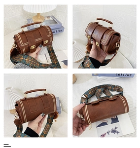 Detailed close-up of a vintage brown cylindrical bag with metal studs and printed strap