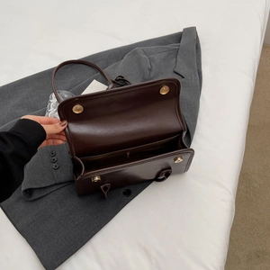 Detail view of the deep brown leather bag interior with zipper pocket and magnetic closure