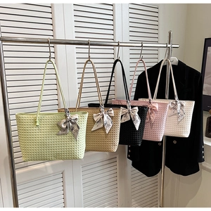 Detail view of woven tote bags in five colors with floral silk scarf bow accents
